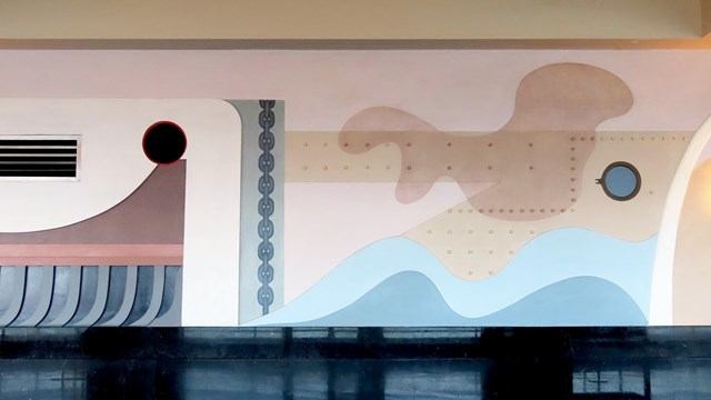 an abstract wall mural of large shapes painted in muted colors, resembling nautical designs.