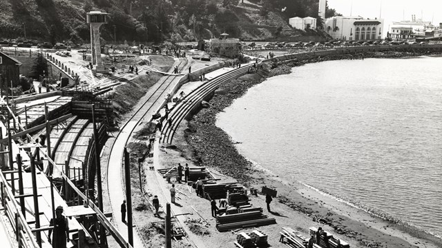 historical photo of the Aquatic Park Bathhouse being built, with scaffolding along the shoreline.
