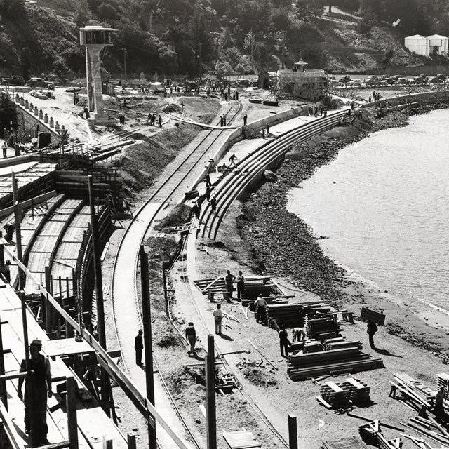 historical photo of the Aquatic Park Bathhouse being built, with scaffolding along the shoreline.