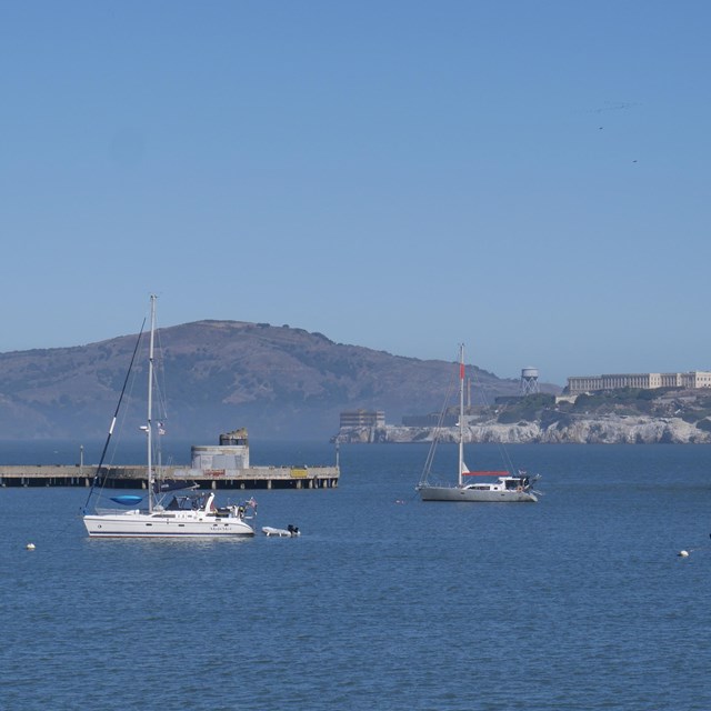 sailboats sit anchored in Aquatic Park Cove