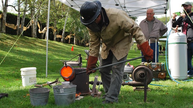 sculptor pouring hot metal 