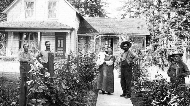 Historic photo of a family in front of their house
