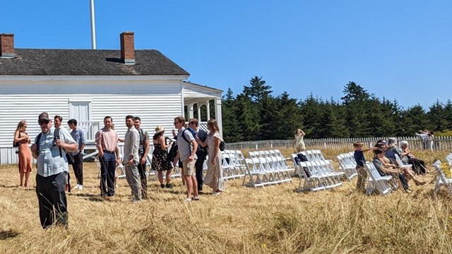 A wedding gathers at outside a historic building