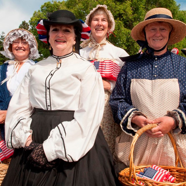 Women dressed in period clothing from the 1800s.