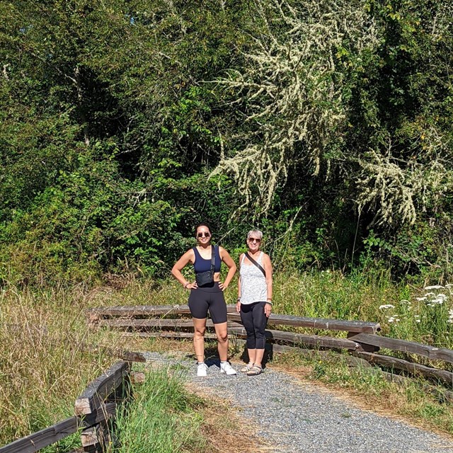 photograph of two people hiking on a trail