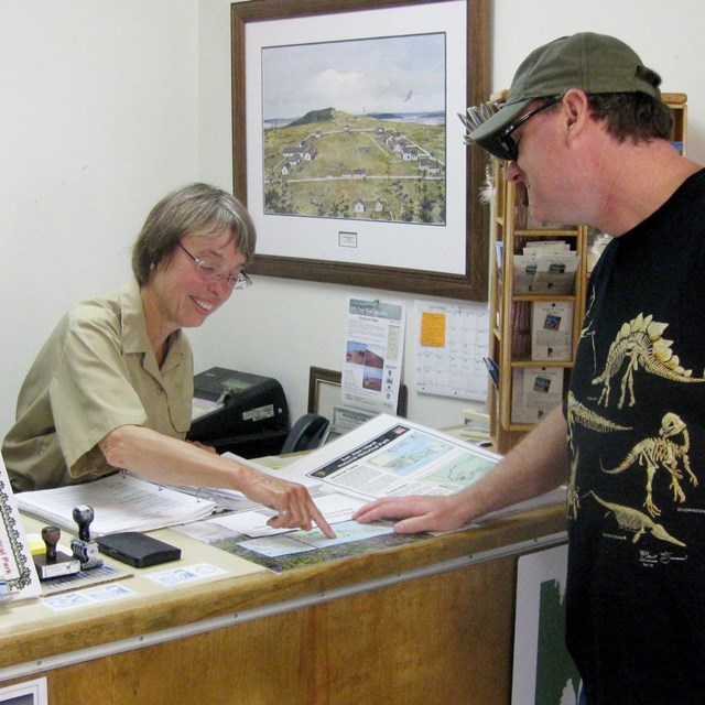 A Volunteer-In-Park gives directions to a visitor.