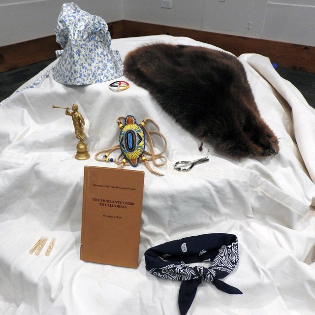 Various props rest on a canvas wagon cover. 