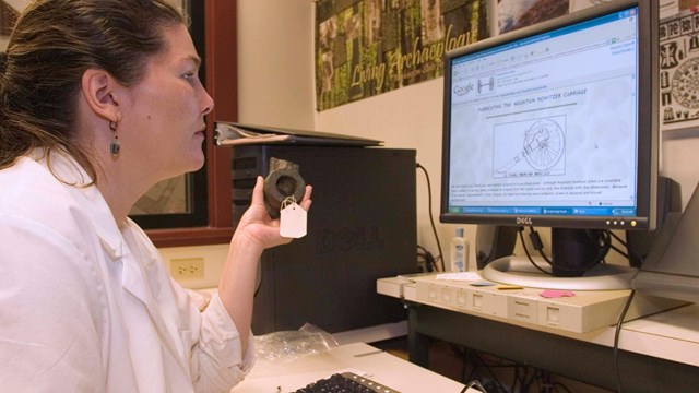 A woman looks at a computer screen