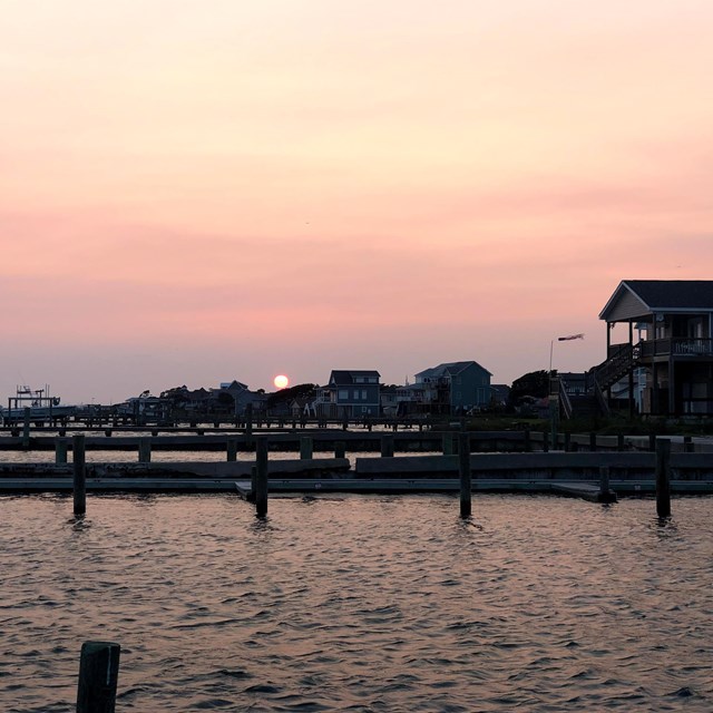 sunset over piers and houses on the water