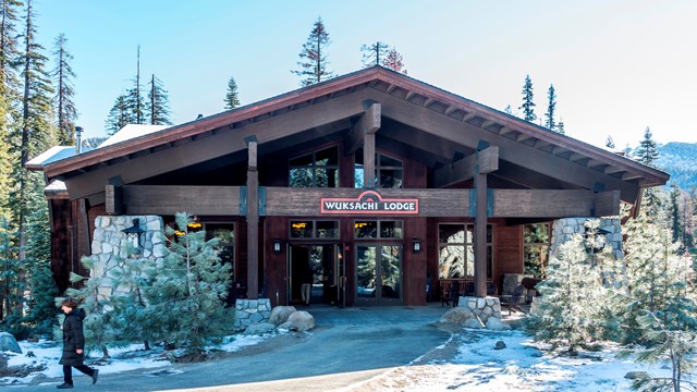 A rustic-styled lodge with light snow on the ground. Photo by Alison Taggart-Barone.