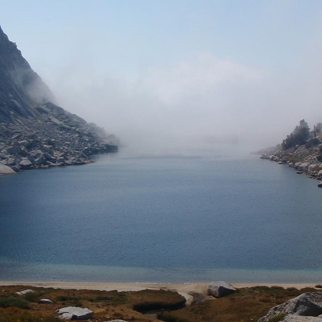 Large lake with rocky shores and far end appears to disappear into clouds