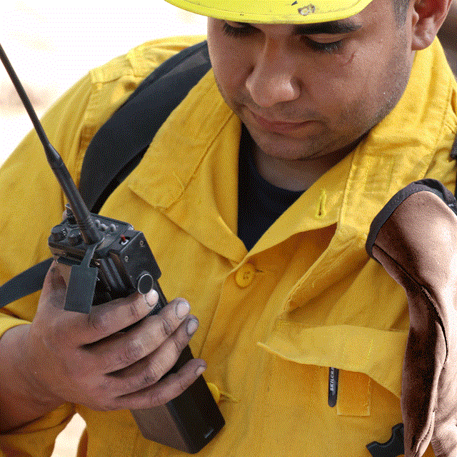A Firefighter holds a radio
