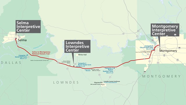 View looking upwards at a tall tan brick building with a National Park Service logo.