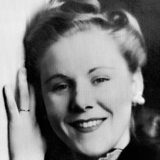 Black and white photo of a middle-aged white woman posing for a photo.