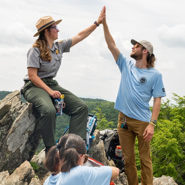 Park Ranger and volunteer high-fiving 