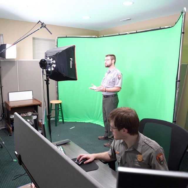 A behind the scenes look of rangers in a studio with a green screen.