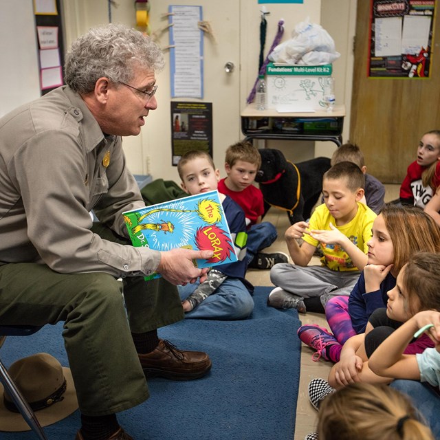 A ranger reading to kids in a classroom.
