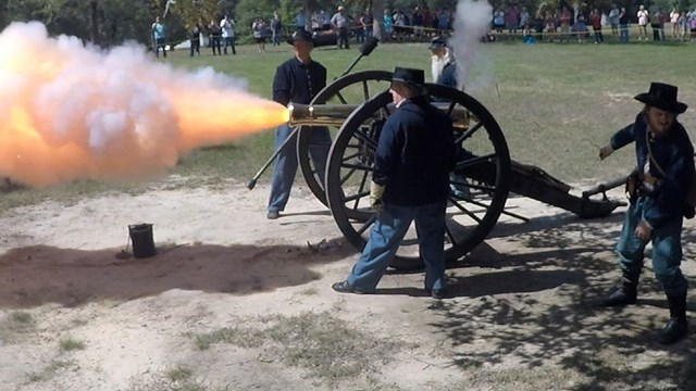 Fire and smoke belch from a fired bronze cannon. 
