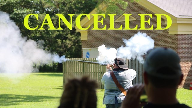 Living historian in uniform fires a musket. 