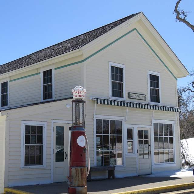 A large white building with big front window has a sign that reads 