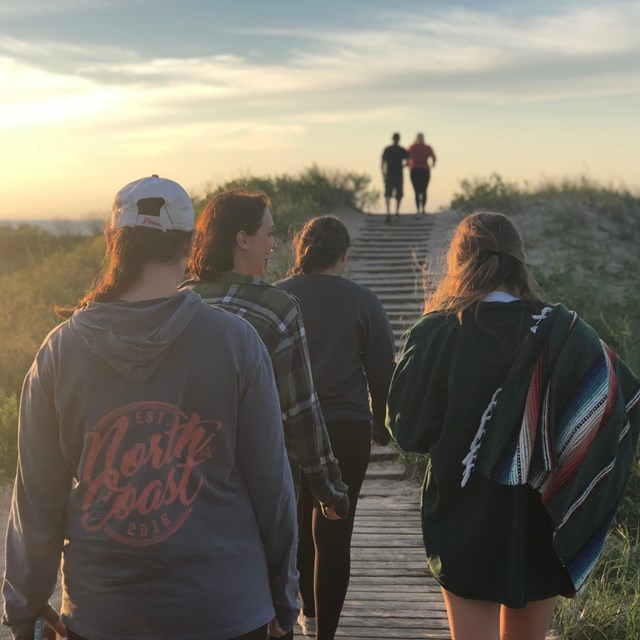 A group of people walk to the beach