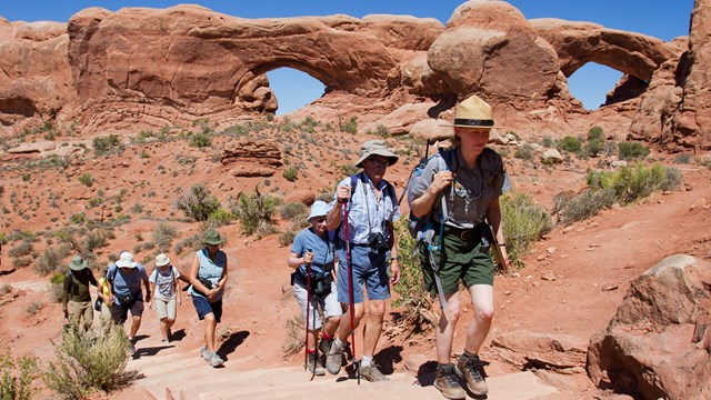 Hikers follow a ranger in Arches National Park.