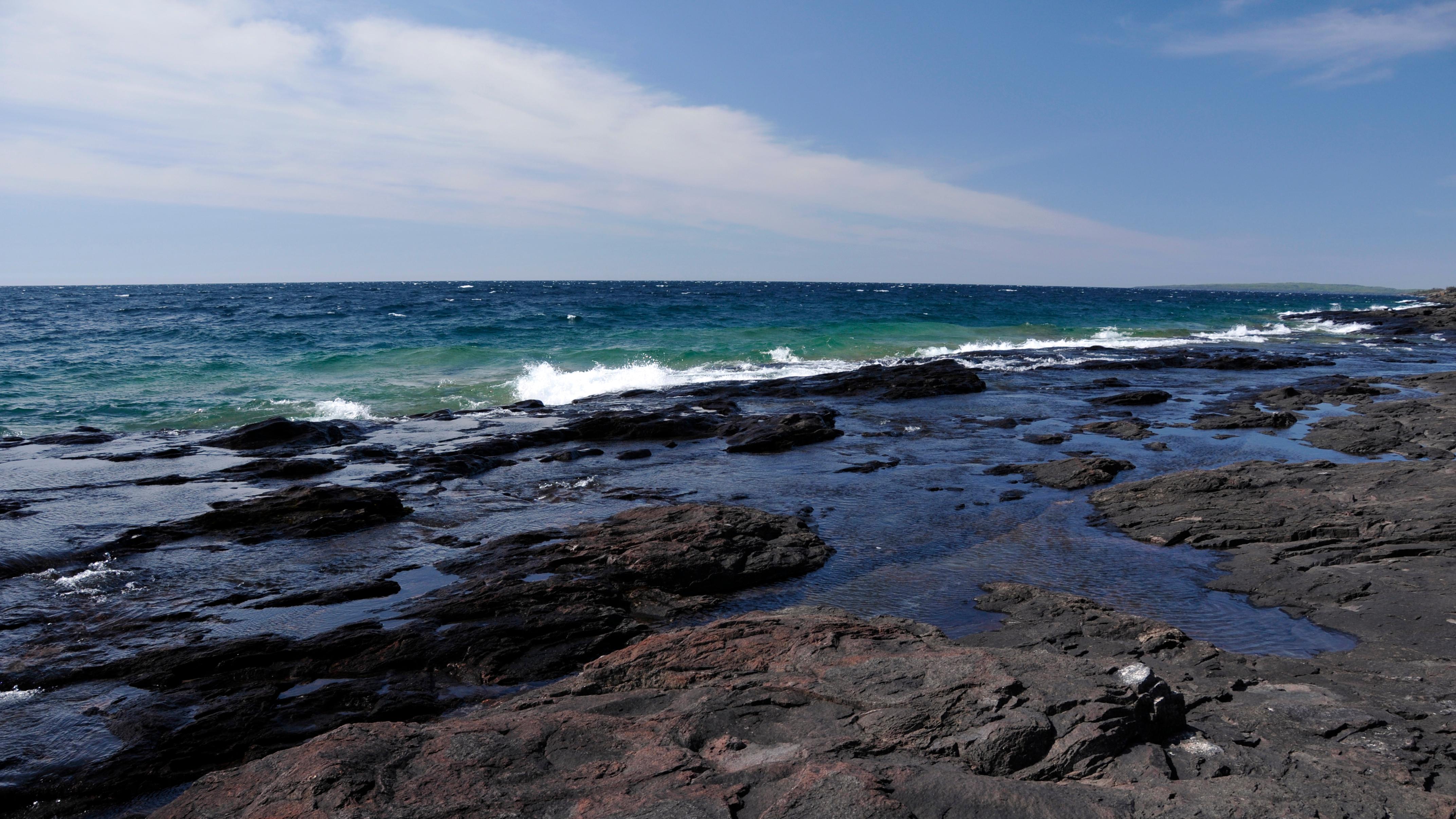 Waves crash on a bedrock shelf along the shore of Lake Superior.
