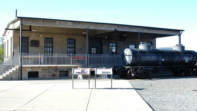 Photo of the restored DL&W Oil House with a historic tank car nearby
