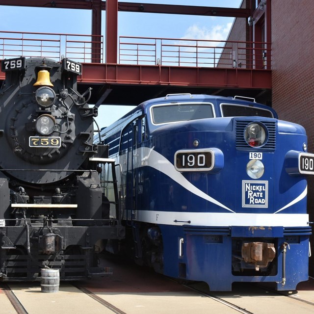 Two nickel plate locomotives parked outdoors