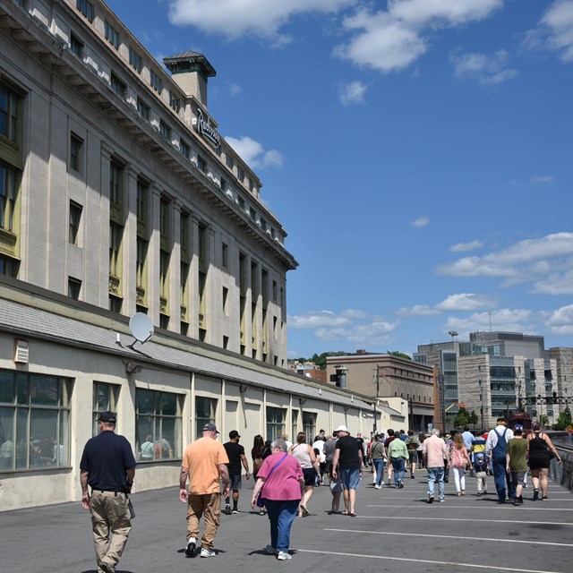 A group of 40 people walk outside along an historic hotel building