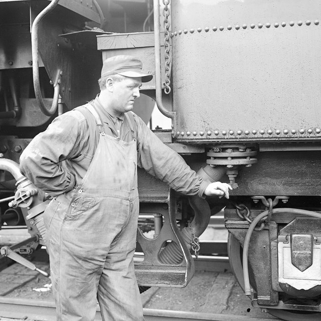 Railyard engineer next to locomotive