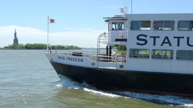 A Statue Cruises ferry full of visitors departs Ellis Island headed towards Liberty Island.