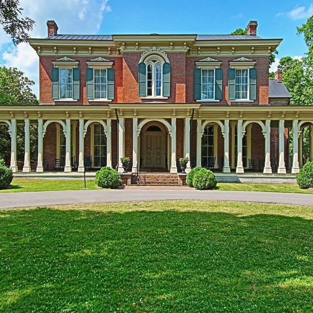 A brick mansion with 7 arches in front of the porch.