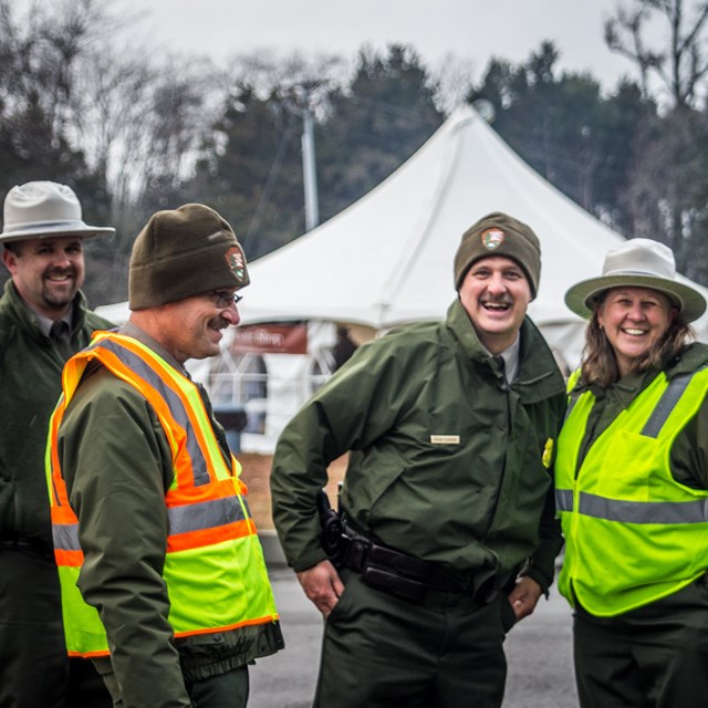 Four Park Rangers smiling at a camera