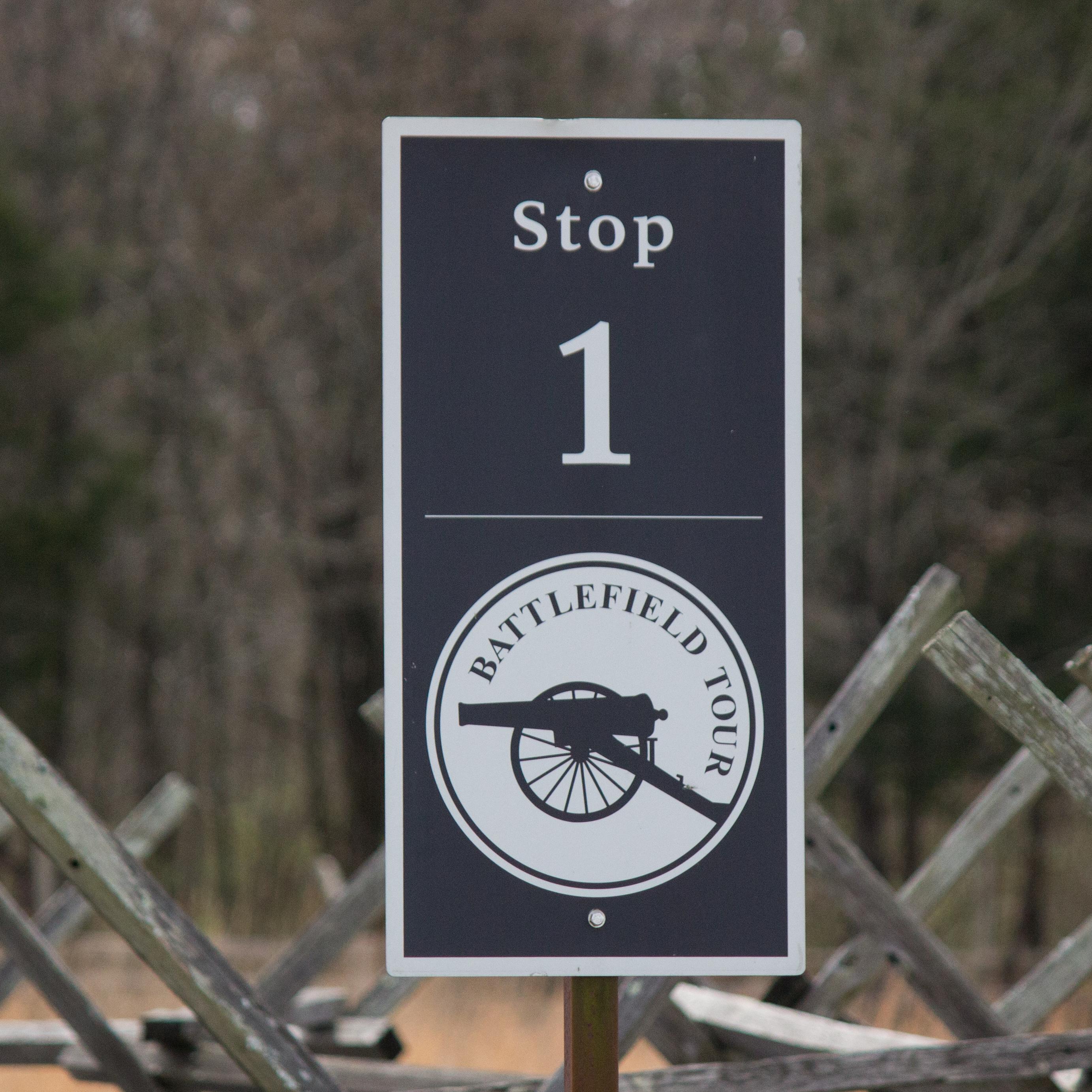 A black and white sign that says Battlefield Tour with the picture of a Civil War cannon in profile.