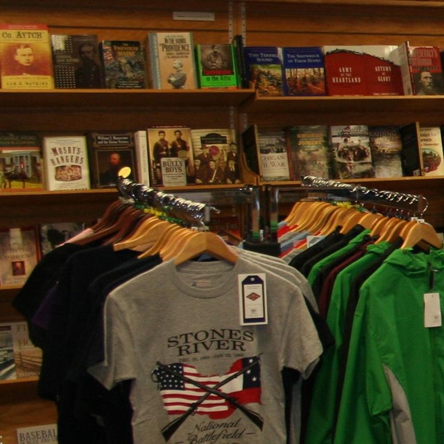 A table has numerous Civil War related items. Shelves of books line the wall.