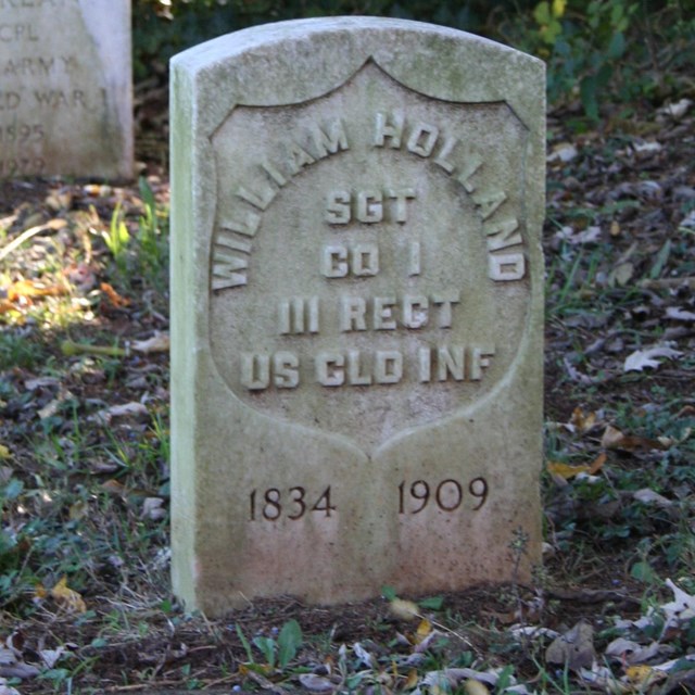 Two grey military headstones, the nearest reading 
