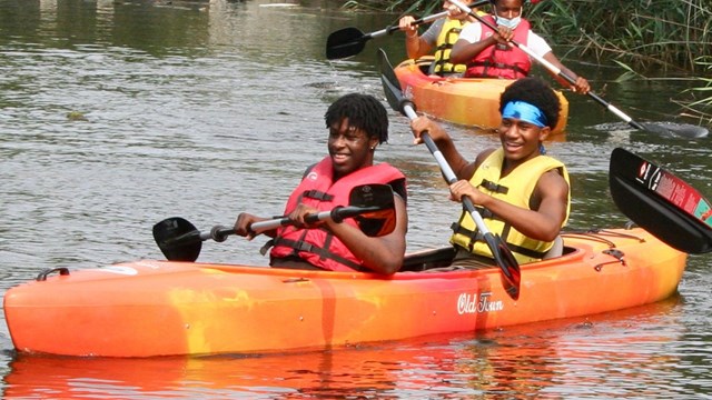 People kayaking near wetlands