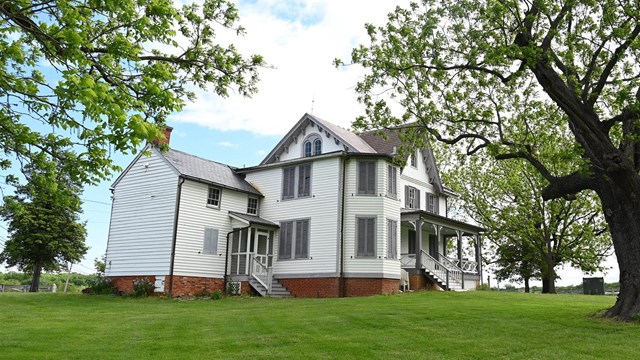 The house at Todd's Inheritance sitting on a green field.