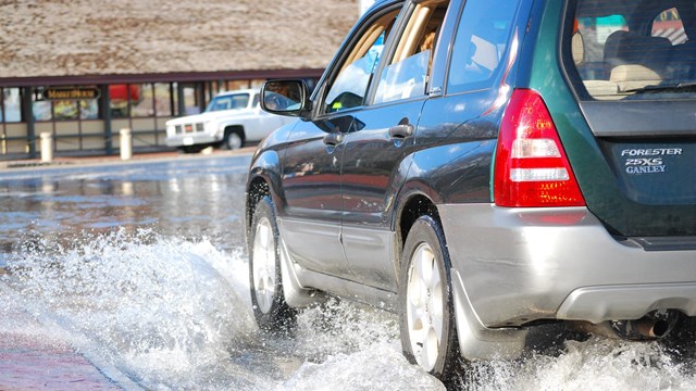 A car driving through high water on a street.