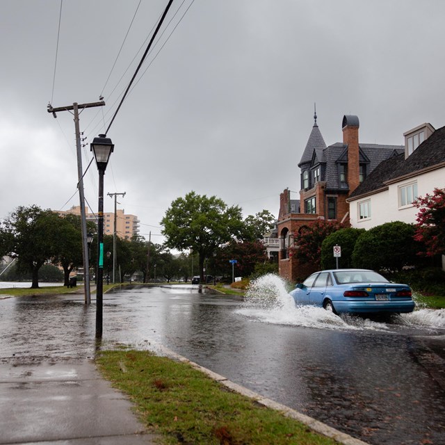 Car drives through a flooded street