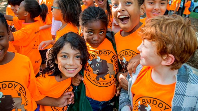 A group of smiling children in orange shirts