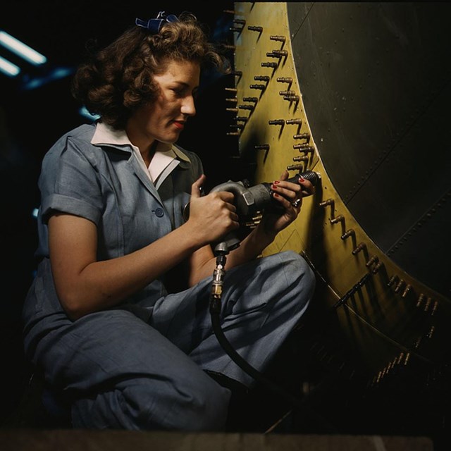 A female riveter works on an airplane in this 1939 image. Library of Congress