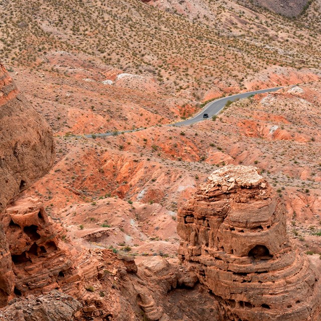 A road cuts through a desert and red rock environment.