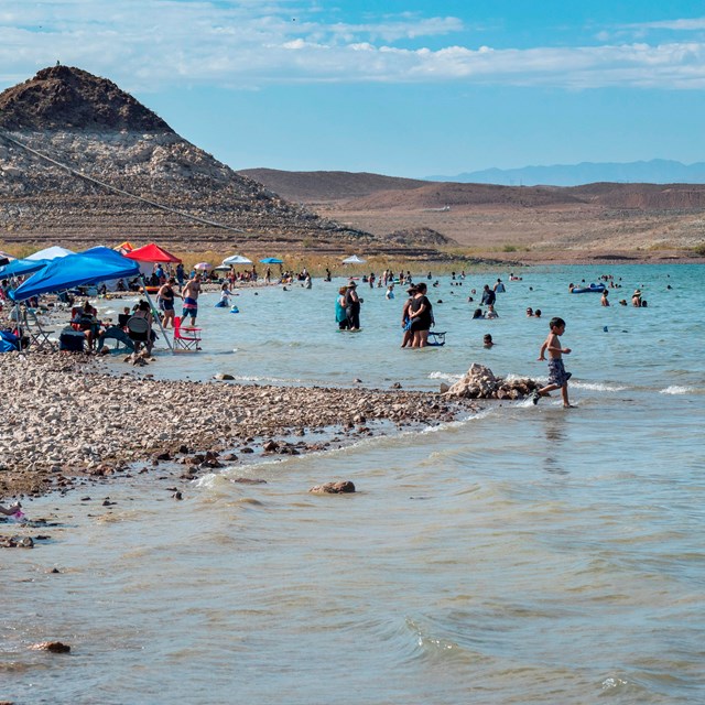 Tents and chairs next to a body of water