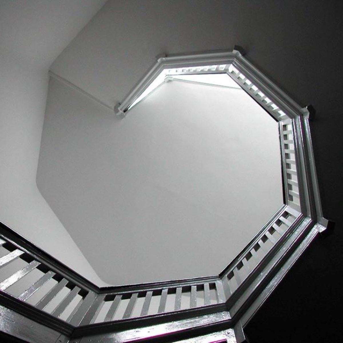 A black and white photograph of a spiral staircase.
