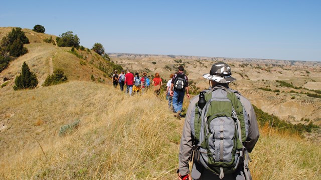 A ranger-led hike follows a trail into the badlands.