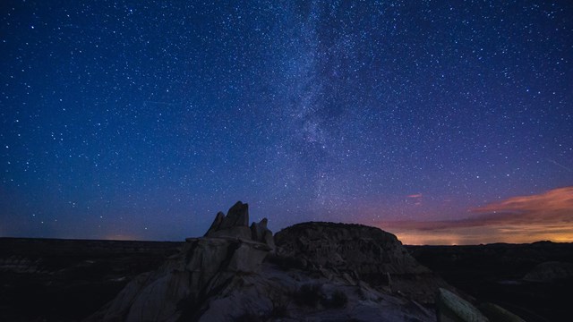 A butte lit by the Milky Way.