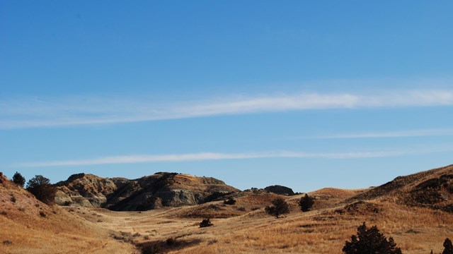 A dry grassland with scattered buttes.