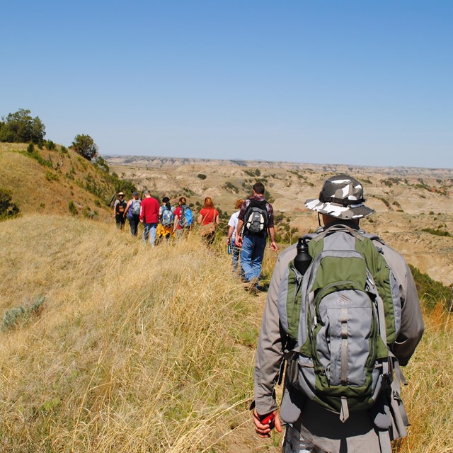 A ranger-led hike follows a trail into the badlands.